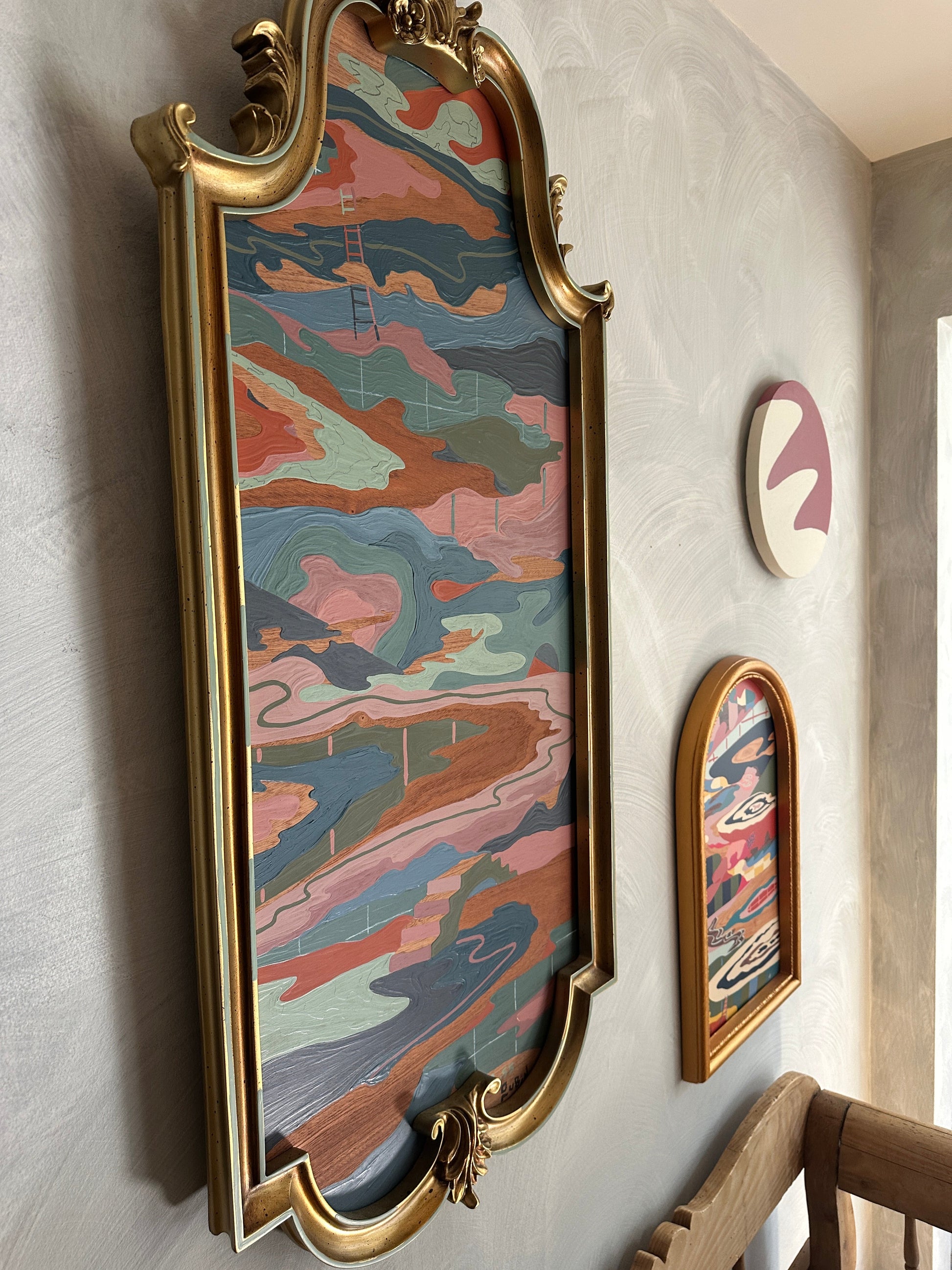 Abstract landscape on wood in vintage frame by Russ Rubin - angle view on wall with other art