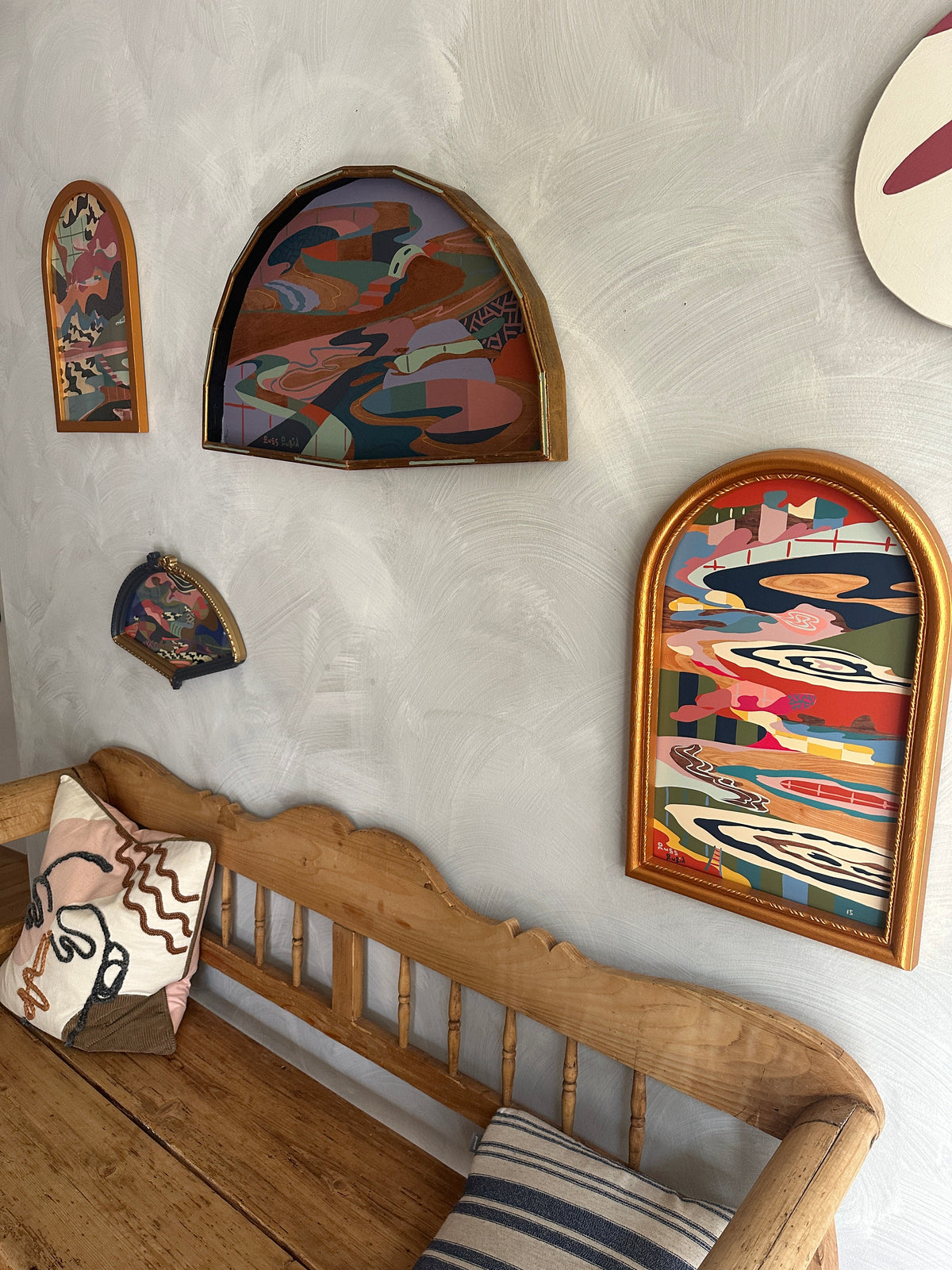Abstract landscape painting on wood in fan shaped frame by Russ Rubin - angle view on wall with other art
