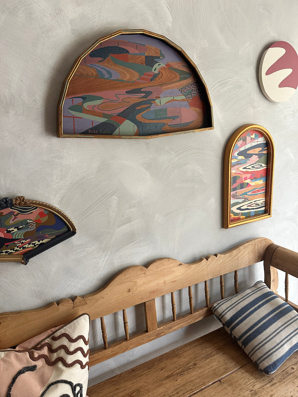 Abstract landscape painting on wood in fan shaped frame by Russ Rubin - angle view on wall with other art
